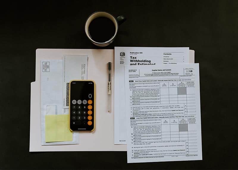 IRS and Tax Fraud Whistleblowers - Open Folder With Tax Documents and Phone