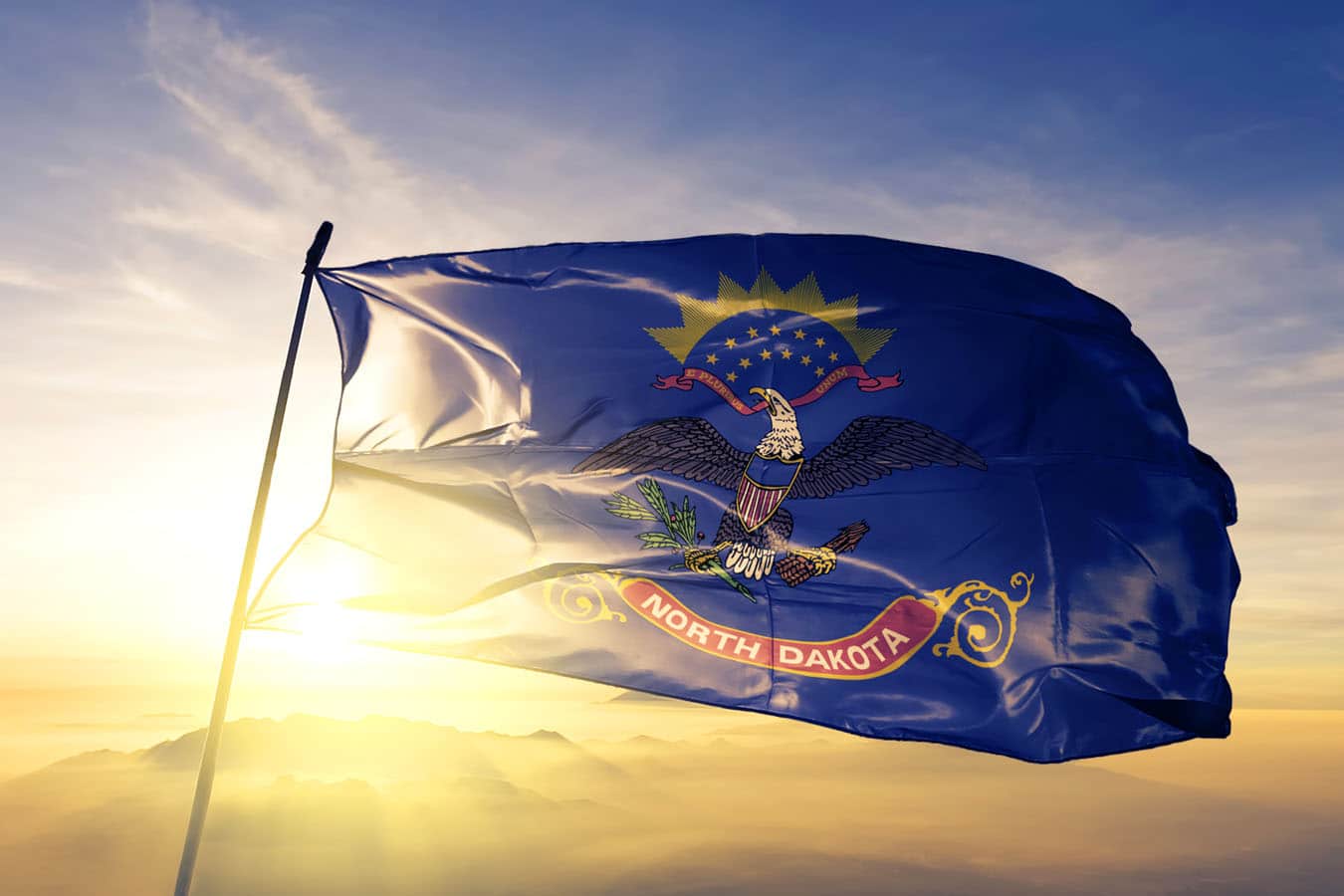 North Dakota state of United States flag textile cloth fabric waving on the top sunrise mist fog
