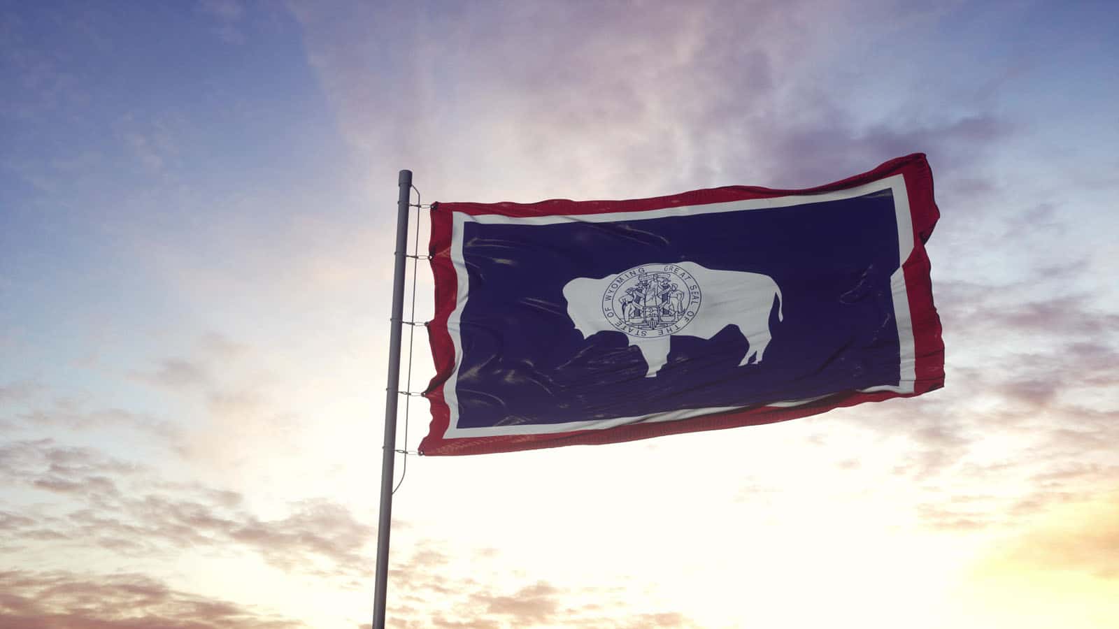 State flag of Wyoming waving in the wind. Dramatic sky background. 3d illustration